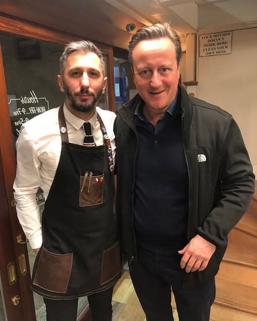 David Cameron with a Groomsmith barber at the shop door